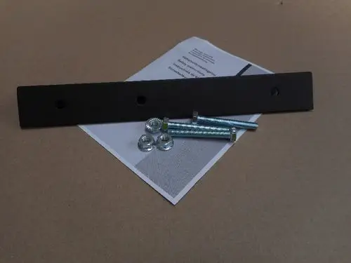 Schwarzes Winkelprofil mit zwei Löchern, verpackt neben drei Schrauben und Unterlegscheiben auf einem technischen Dokument von Remeha.